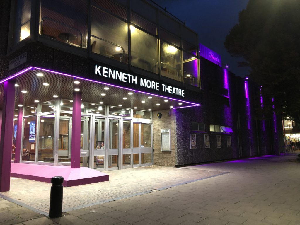 outside view of Kenneth More theatre at night with purple lighting around the theatre
