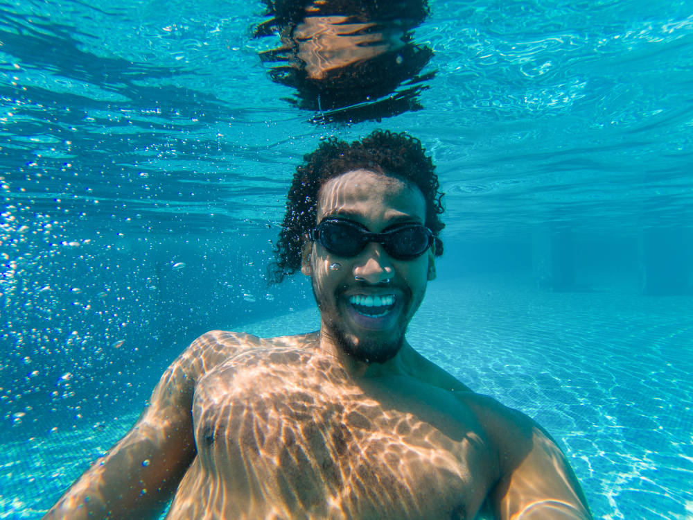 Black man smiling underwater in the pool