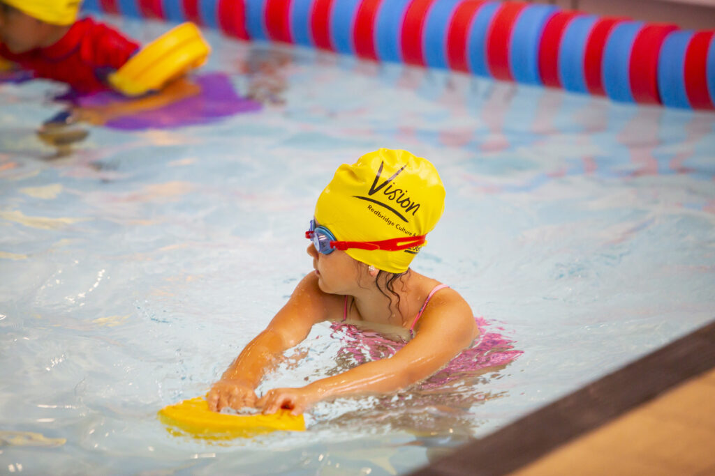 child swimming with floats