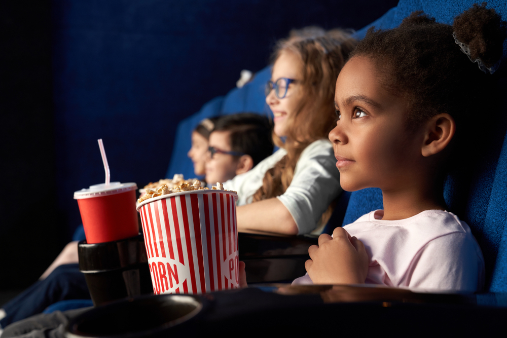 young children at cinema eating popcorn